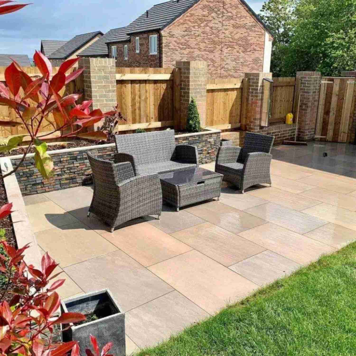 An outdoor porcelain-paved seating area beside a lawn, as illustrated in the source patio-cleaning guide.