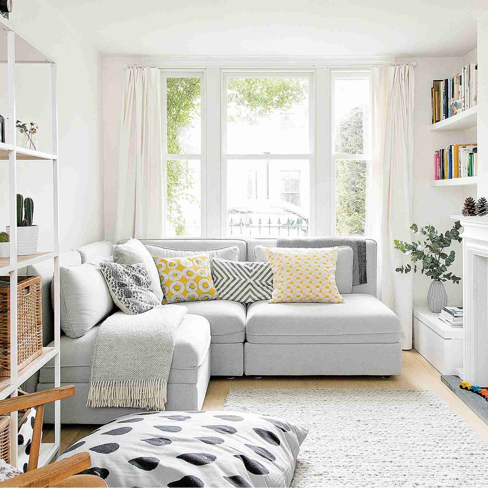 A pale corner sofa beneath a window in a small living room, used as an upholstery illustration in the source powder-refresh feature.