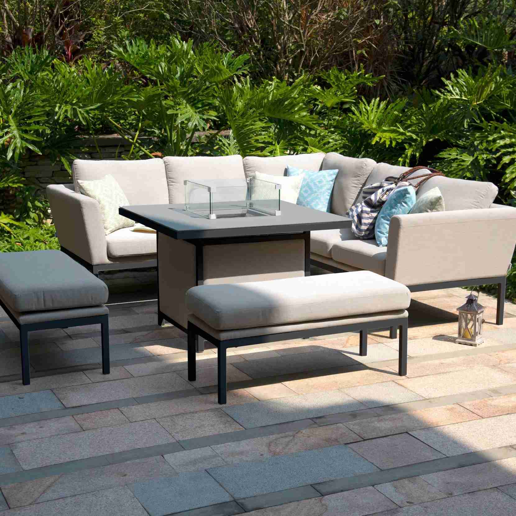 A light outdoor corner sofa with cushions beside a patio table and low footstool, illustrating the furniture in the source cleaning guide.